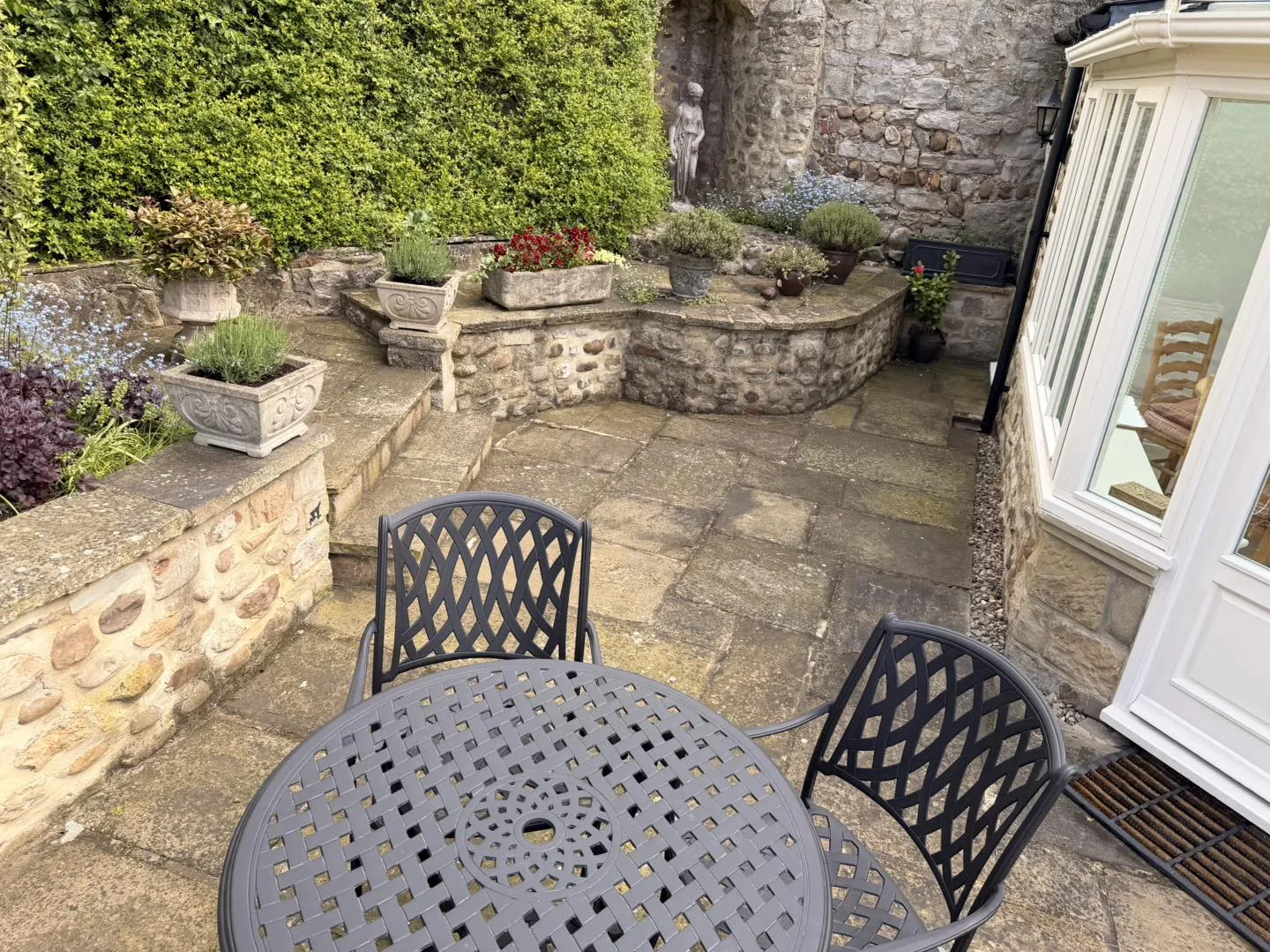 Walled stone patio clean before cleaning by Hopkins Exterior Cleaning